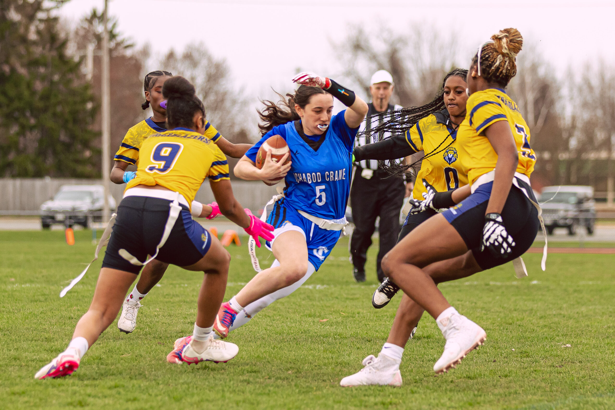 Ichabod Crane CSD Flag Football team player with the football team surrounded by challenging team.